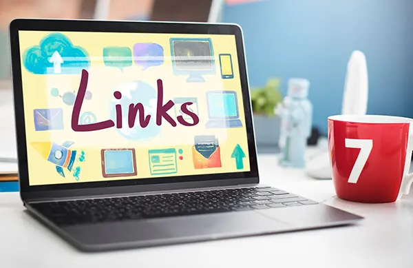 A laptop on a table with the concept of links on the screen