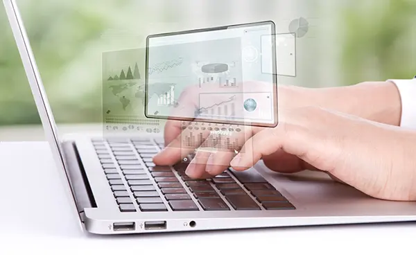 A person working on a laptop, checking performance metrics and graphs